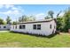 Side view of a single-story home featuring a white exterior and well-maintained lawn at 2105 9Th Ne St, Winter Haven, FL 33880