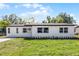 Charming single-story home featuring a white exterior, brick driveway, and well-maintained lawn at 2105 9Th Ne St, Winter Haven, FL 33880