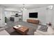 Bright living room showcasing wood floors, a modern coffee table, and an open floor plan to the kitchen at 2105 9Th Ne St, Winter Haven, FL 33880