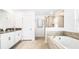 Luxurious bathroom featuring a soaking tub, glass shower, and double vanity sinks at 2916 Simile St, Kissimmee, FL 34746