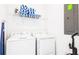 Functional laundry room equipped with a washer, dryer, storage shelf, and ironing board at 2916 Simile St, Kissimmee, FL 34746