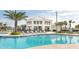 Beautiful community pool surrounded by tropical landscaping and comfortable lounge chairs for residents to enjoy at 2916 Simile St, Kissimmee, FL 34746