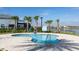 Community spa with comfortable swing feature and lake views surrounded by palm trees and tile decking at 2916 Simile St, Kissimmee, FL 34746