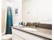 Bright bathroom with single sink, quartz countertop, and shower with a teal curtain at 2936 Protagonist St, Kissimmee, FL 34746