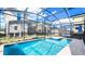 Enclosed backyard pool with spa and clear blue water, surrounded by green plants at 2936 Protagonist St, Kissimmee, FL 34746