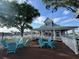 Community clubhouse deck with blue lounge chairs overlooking the pool and lake at 3084 Ella Way, St Cloud, FL 34771