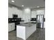 Modern kitchen featuring white cabinets, stainless steel appliances, and a gray center island at 3084 Ella Way, St Cloud, FL 34771
