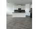 Modern kitchen with black countertops, white cabinets, and stainless steel appliances at 3084 Ella Way, St Cloud, FL 34771
