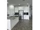 Bright kitchen with white cabinets, stainless steel appliances, and a gray island with a sink at 3084 Ella Way, St Cloud, FL 34771