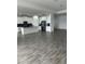 Spacious living area with open kitchen and gray wood-style flooring at 3084 Ella Way, St Cloud, FL 34771