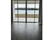 Living room showcasing gray wood-style tile flooring and sliding glass doors with lake view at 3084 Ella Way, St Cloud, FL 34771