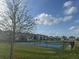 View of community pickleball courts surrounded by green space and neighborhood homes at 3084 Ella Way, St Cloud, FL 34771