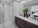 Stylish bathroom featuring a double vanity, dark cabinets, and a glass-enclosed shower at 3173 Douglas Fir Dr, Apopka, FL 32703