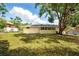 Spacious backyard featuring a well-maintained lawn, mature tree, and the home's rear facade at 326 Evergreen Ct, Apopka, FL 32712