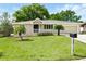 Charming single-story home with a well-manicured lawn, attached garage, and inviting front porch at 326 Evergreen Ct, Apopka, FL 32712