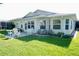 Well-maintained backyard with lush lawn, brick patio, and charming outdoor seating area at 32900 Crooked Oaks Ln, Leesburg, FL 34748
