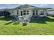 Secluded backyard with comfortable outdoor seating, lush green grass, and well maintained landscaping at 32900 Crooked Oaks Ln, Leesburg, FL 34748