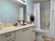 Bright bathroom features a shower-tub combo, neutral color palette, and a modern vanity at 32900 Crooked Oaks Ln, Leesburg, FL 34748