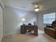 Bedroom with neutral walls, carpet and ceiling fan, plus desk and comfortable armchair at 32900 Crooked Oaks Ln, Leesburg, FL 34748