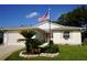Inviting home exterior with manicured front yard, featuring a pink door and shutter accents at 32900 Crooked Oaks Ln, Leesburg, FL 34748