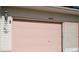Single car garage door in a cheery pink color at 32900 Crooked Oaks Ln, Leesburg, FL 34748