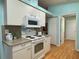 Cozy kitchen with white appliances, light countertops, and plenty of cabinet space at 32900 Crooked Oaks Ln, Leesburg, FL 34748