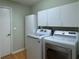 Well-equipped laundry room with modern appliances and plenty of storage space, next to an access door at 32900 Crooked Oaks Ln, Leesburg, FL 34748