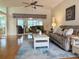 Inviting living room with vaulted ceiling, sliding glass doors, and comfortable sofa at 32900 Crooked Oaks Ln, Leesburg, FL 34748