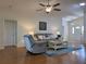 Bright and airy living room featuring wood floors, comfortable seating, and a modern ceiling fan at 32900 Crooked Oaks Ln, Leesburg, FL 34748