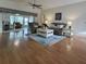 Spacious living room with wood floors, comfortable seating, and lots of natural light from sliding glass doors at 32900 Crooked Oaks Ln, Leesburg, FL 34748