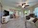 Bright sunroom with tile flooring, ceiling fan, and sliding glass doors to the living room at 32900 Crooked Oaks Ln, Leesburg, FL 34748