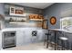 Bar area with custom wood detailing, floating shelving, granite countertop and wine refrigerator at 3647 Farm Bell Pl, Lake Mary, FL 32746
