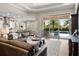 Open living room with a large sectional, backyard pool view, and seamless flow to the kitchen and dining area at 3647 Farm Bell Pl, Lake Mary, FL 32746