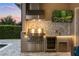A stylish outdoor kitchen with a stainless steel grill and a beverage cooler by the pool and patio at 3647 Farm Bell Pl, Lake Mary, FL 32746