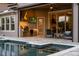 A covered patio with a built-in kitchen, a stainless steel grill, and cozy seating by the sparkling pool at 3647 Farm Bell Pl, Lake Mary, FL 32746