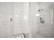 White tiled walk-in shower featuring dual shower heads, tiled seat, and built-in niche at 3647 Farm Bell Pl, Lake Mary, FL 32746