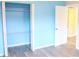 Blue bedroom features wood-look floors, closet with shelving, and lots of natural light at 3713 N Econlockhatchee Trl, Orlando, FL 32817