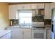 Updated kitchen with stainless steel appliances, granite counters, white cabinetry, and decorative tile backsplash at 3713 N Econlockhatchee Trl, Orlando, FL 32817