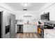 Bright kitchen with stainless steel appliances, white cabinets and countertops, and a wood-look floor at 376 Orange Ave, Longwood, FL 32750