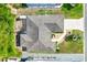 Aerial view showcases the layout of a well maintained home with lush garden, patio, and concrete driveway at 428 Tarrson Blvd, Lady Lake, FL 32159