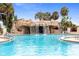 Community pool with decorative waterfall feature, clear blue water, and surrounding landscaping at 428 Tarrson Blvd, Lady Lake, FL 32159