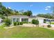 Well-maintained single-story home featuring manicured landscaping, lush green lawn and charming curb appeal on a sunny day at 428 Tarrson Blvd, Lady Lake, FL 32159