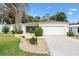Charming single-story home featuring manicured landscaping, lush green lawn, concrete driveway and attached garage at 428 Tarrson Blvd, Lady Lake, FL 32159