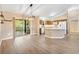 Open-concept living room featuring wood-look floors and a seamless flow to the kitchen and screened-in porch at 428 Tarrson Blvd, Lady Lake, FL 32159