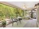 Relaxing screened lanai with ceiling fan, table set, hot tub, and view to the lush backyard at 428 Tarrson Blvd, Lady Lake, FL 32159