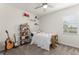 Bedroom with a white bed, shelving, and guitar, bathed in natural light from a large window at 4599 Storytelling Way, Kissimmee, FL 34746