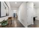 Hallway with wood-look flooring, showcasing a modern table and a plant, leading to additional rooms at 4599 Storytelling Way, Kissimmee, FL 34746