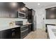 Well-equipped kitchen featuring stainless steel appliances, dark cabinets, and sleek countertops with a modern backsplash at 4599 Storytelling Way, Kissimmee, FL 34746