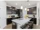 This contemporary kitchen features dark cabinets, white countertops, and a large center island with bar stools at 4599 Storytelling Way, Kissimmee, FL 34746
