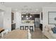 Open-concept kitchen boasts stainless steel appliances, dark cabinetry, and a center island with bar stool seating at 4599 Storytelling Way, Kissimmee, FL 34746